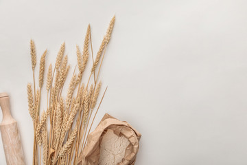 top view of wheat spikes, rolling pin and flour package isolated on white