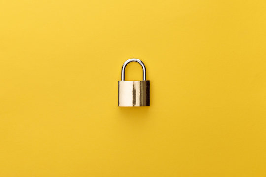 top view of metal padlock on yellow background