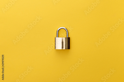 Fotomural top view of metal padlock on yellow background