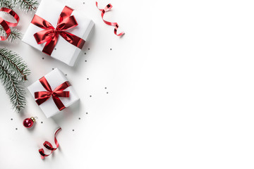 Wall Mural - christmas fir branches with gift boxes with red ribbon on white paper background with bokeh, light. 