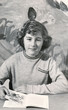 Vintage retro 1950s monochrome portrait of young girl holding a book and looking into the camera