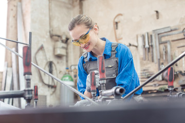 Wall Mural - woman in Metal workshop with tools and workpiece