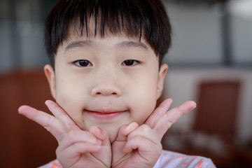 Portrait of cute asian boy with v-sign