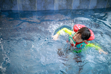 Wall Mural - Cute little boy having fun in the swimming pool