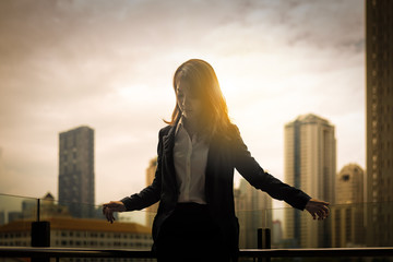 silhouette of business woman in sunrise with city background