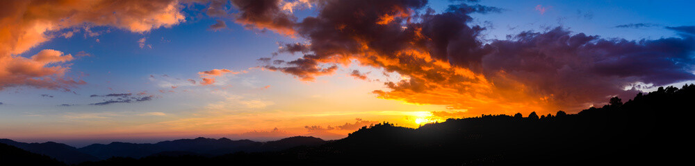 Wall Mural - Panoramic landscape of Mountains at sunset with clouds