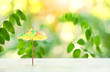 Miniature paper sun umbrella on abstract nature background. Vacation holiday minimal concept. cocktail umbrella on summer template. shallow dept, close up, soft selective focus