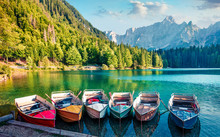 Six Pleasure Boats On Fusine Lake. Colorful Evening Scene Of Julian Alps With Mangart Peak On Background, Province Of Udine, Italy, Europe. Traveling Concept Background.