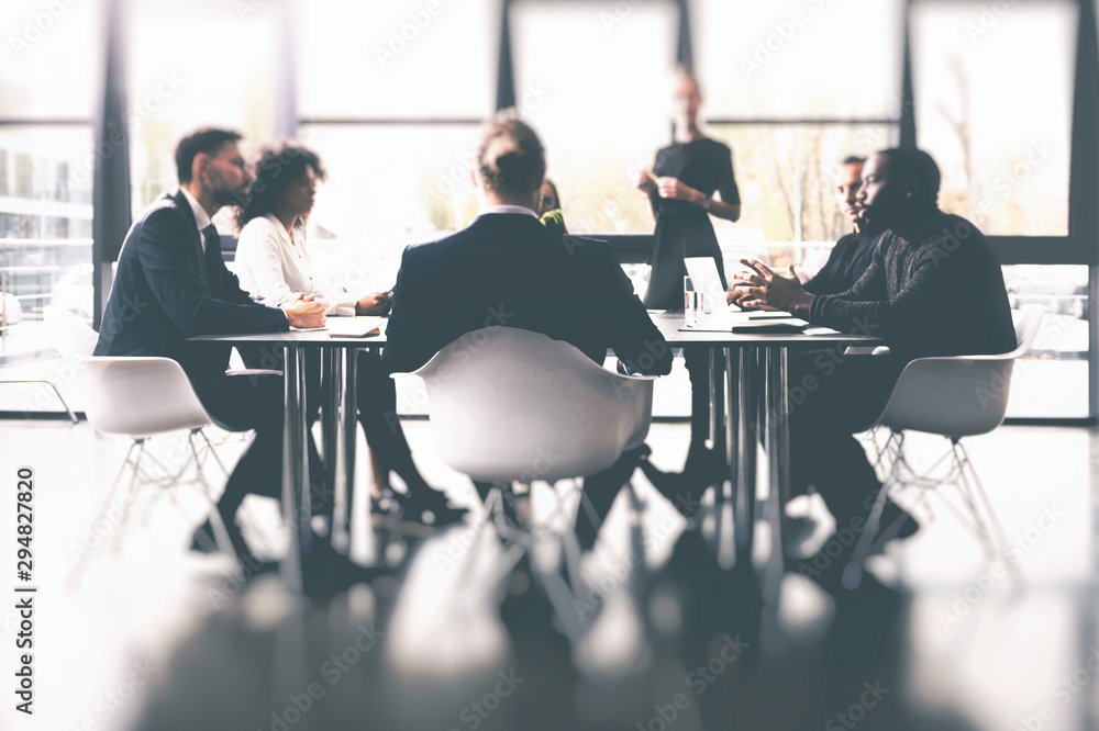 Background concept with business people sitting at the meeting table in the office near a window glass - obrazy, fototapety, plakaty 