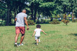 © LIGHTFIELD STUDIOS - back view of african american father and son playing football in park