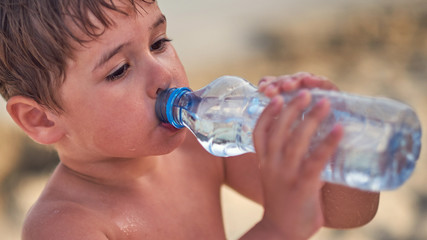  child drinking from a plastic bottle