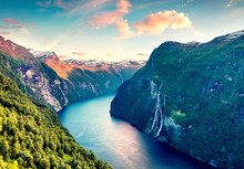 Splendid Summer Sunset Of Sunnylvsfjorden Fjord Canyon, Geiranger Village Location, Western Norway. Aerial Evening View Of Famous Seven Sisters Waterfalls. Beauty Of Nature Concept Background.