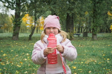 Portrait of funny lovely little girl blowing soap bubbles