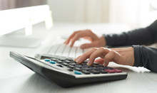 Hands Of A Financial Analyst Count On A Calculator And Working At A Computer. Woman Accountant At The Workplace. 