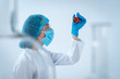 © brizmaker - Scientist woman holding medical glass bottle with liquid, making laboratory analysis