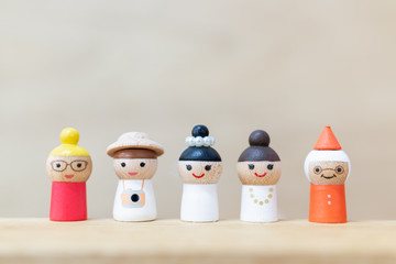 Miniature toy : cute wooden doll with  happy face on wooden background