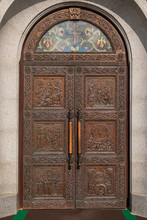 Wooden Arched Door Of Church With Engraving Of The Scenes From Bible And Stained Glass