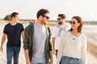 © Syda Productions - friendship, leisure and people concept - group of happy friends walking along beach in summer
