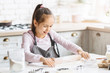 © Prostock-studio - Preteen girl using rolling pin, practicing with dough on kitchen table
