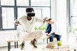 © LIGHTFIELD STUDIOS - african american businessman using vr headset and squatting on desk while colleagues working in office