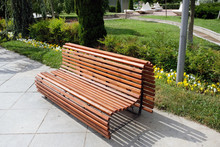 Beautiful Comfortable Wooden Bench Of Brown Slats With A Smooth Transition. Arrangement Of The Park Comfortable Places For Recreation, A Large Wooden Bench In The Park In The City Center.