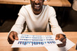 © LIGHTFIELD STUDIOS - cropped view of happy african american businessman holding paper with graphs and charts