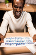 © LIGHTFIELD STUDIOS - selective focus of happy african american businessman holding paper with graphs and charts