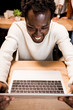 © LIGHTFIELD STUDIOS - smiling african american businessman looking at laptop while working at night in office