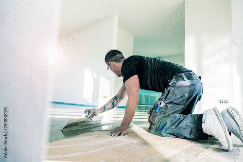 Male Worker Working With Self Levelling Cement Mortar During Floor