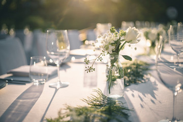 beautiful outdoor table setting with white flowers for a dinner, wedding reception or other festive 