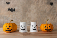 Front View Of Halloween Pumpkins, Yellow Pumpkins Ghost And Paper Cup Ghost On Cement Wall Background., Bat And Spider Background With Copy Space For Text. Halloween Concept.
