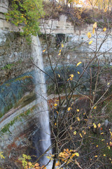 Wall Mural - large waterfall with high cliffs and trees with autumn foliage