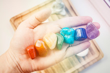 Woman Hand Sowing All Seven Color Chakra Crystal Stones. Chakra Energy Flow Healer Concept.