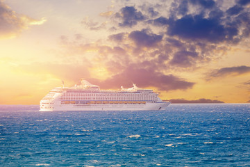 Luxury cruise ship sunset in blue sea with clouds