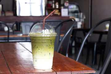 Wall Mural - Iced matcha latte green tea in plastic cup. Healthy drink. Favorite asian traditional beverage.