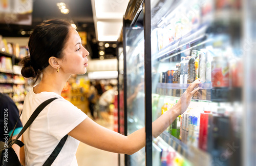 Cuadros en Lienzo Portrait of caucasian woman looking at product at grocery store