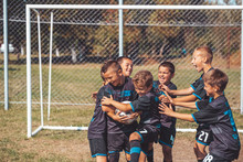 Kids Soccer Players Celebrating In Hug After Victory
