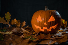 Halloween Carving Pumpkin On A Leafs. Shining Jack-o'-lantern.