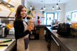 © Westend61 - Portrait of smiling young woman behind the counter in a cafe