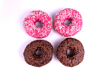 on a white background, two donuts covered with pink icing with white powder and two with chocolate icing and brown powder are closely identified.