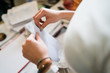 © Miljan Živković - Close up on girl female woman hands holding and opening white envelope by the table at office work or at home with bills mail or insurance contract invoice letter