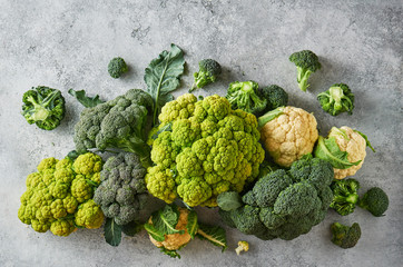 Wall Mural - Fresh green cabbage, cauliflower and broccoli on a light textured background.