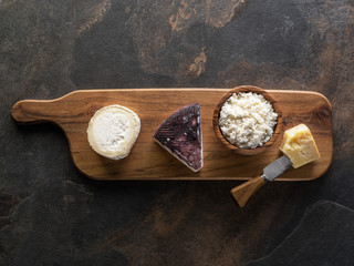 Wall Mural - Cheese platter with different homemade organic cheeses on stone background. Top view.