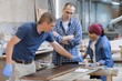 © Valerii Honcharuk - Workers in carpentry woodworking workshop, varnishing wooden plank with oil