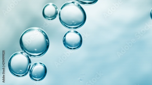 transparent gas bubbles on water surface. Worms-eye low angle with crystal bubbles in purified water on blue background. cosmetic background with copy space