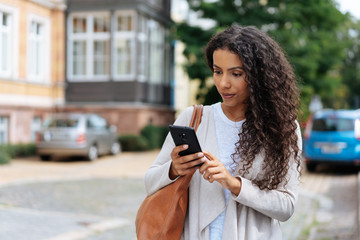 Young woman looking at her phone in consternation