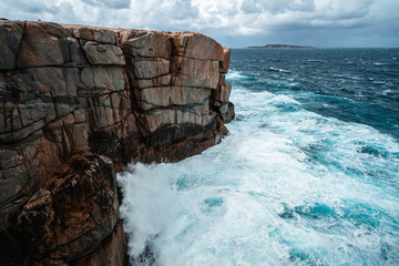 Wall Mural - The Natural Gap, Albany, Western Australia. Dramatic and moody landscape with large rough waves breaking on the rocks. 