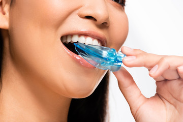 cropped view of asian woman using mouth guard isolated on white