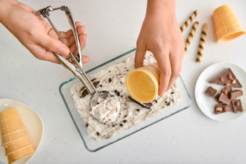 woman preparing tasty ice cream on white background, top view