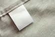 © Kwangmoozaa - White blank laundry care clothing label on gray fabric texture background